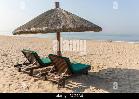 Sedie e ombrellone su una spiaggia tropicale Foto Stock