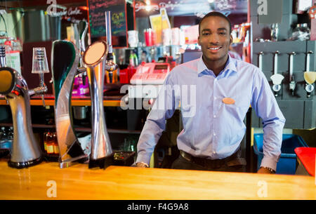 Barman sorridenti in posa vicino a toccare Foto Stock