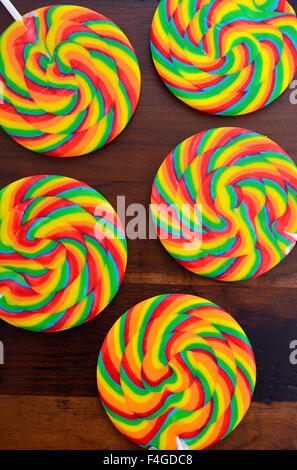 Bright rainbow lollipop candy sul legno scuro tavolo. Foto Stock