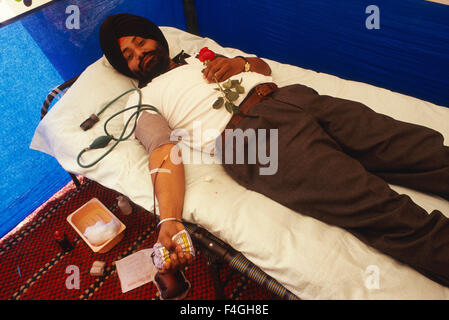 La religione Sikh l uomo la donazione del sangue. La rosa che tiene in mano è un dono ( India) Foto Stock