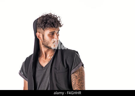 Bello duro giovane uomo in scuro incappucciati t-shirt isolati su sfondo bianco, guardando lontano da un lato Foto Stock
