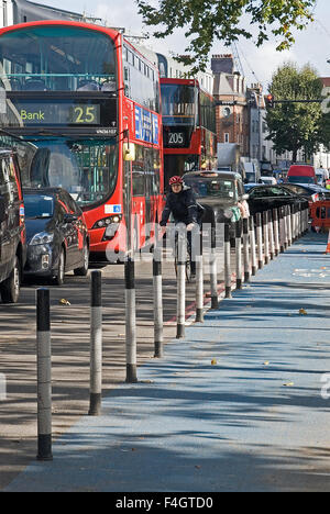 Accodamento di traffico su una strada a Whitechapel, East London come continuo investimento in segregata infrastruttura ciclismo spreme spazio stradale per i veicoli. Foto Stock