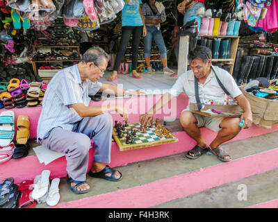 Due uomini filippini giocare una partita a scacchi sul marciapiede. Foto Stock