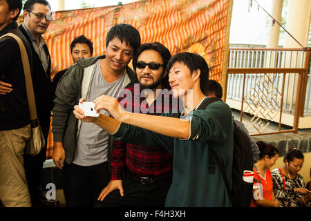 Mcleodganj, Himachal Pradesh. Il 18 ottobre 2015. Inceppamento Lukar tenendo selfies con persone che sono venuti per il turno preliminare di elezione parlamentare a Namgyal monastero. Ringraziamo Abhishek bali/Alamy Live News Foto Stock