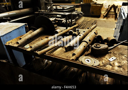 Rusty diversi utensili industriali su una tabella all'interno di una fabbrica Foto Stock