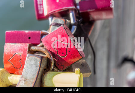 Lucchetti con cuori su una ringhiera a ponte Foto Stock