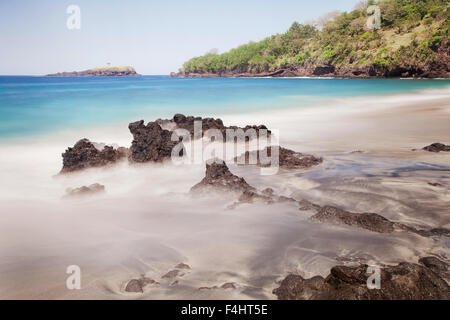 Scenic seascape e lunga esposizione foto di idilliaca spiaggia di Bali con il mare turchese colori e nebbioso acque di marea. Una bella destinazione di viaggio Foto Stock