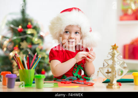 Bambino ragazza facendo da mani le decorazioni di Natale Foto Stock