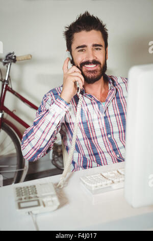 Ritratto di uomo felice parlando al telefono su rete fissa Foto Stock