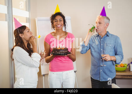 I colleghi di partito di soffiaggio corno nella festa di compleanno di imprenditrice creativa Foto Stock