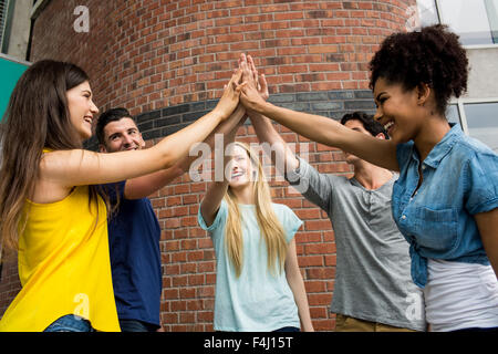 Gli studenti di mettere le mani insieme in unità Foto Stock