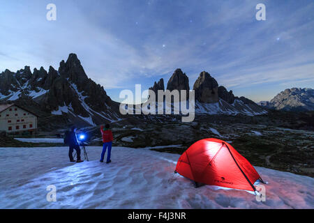 Gli escursionisti ammirare le Tre Cime di Lavaredo prima di trascorrere la notte in tenda, Sesto, Dolomiti, Trentino-Alto Adige, Italia Foto Stock