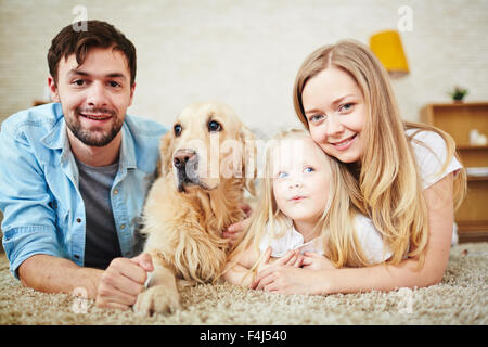 Grazioso fanciullo, i suoi genitori e il PET in un momento di relax a casa Foto Stock