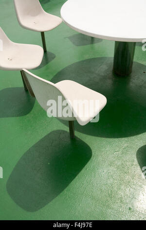 Sedie attorno a un tavolo su un traghetto. Foto Stock