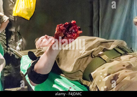 Gli infermieri dalla corazzata Royal Medical Corp (RAMC) assistere ad un soldato che ha avuto la sua mano è stata soffiata da un IED in un ospedale da campo esercitazione Foto Stock