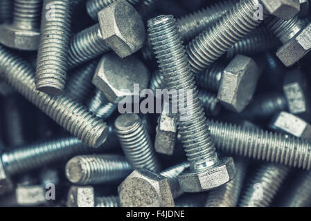 Testa esagonale viti in metallo pila, industriale texture di sfondo, il fuoco selettivo Foto Stock