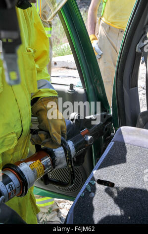 Vigili del fuoco utilizza strumenti di potenza al salvataggio dei passeggeri rimasti intrappolati da un auto Foto Stock