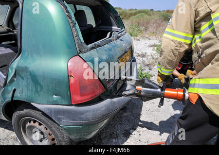 Vigili del fuoco utilizza strumenti di potenza al salvataggio dei passeggeri rimasti intrappolati da un auto Foto Stock