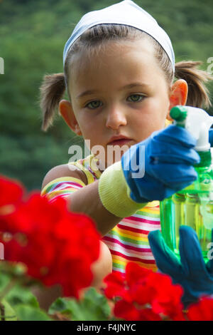 Bambina fiori di irrigazione in giardino Foto Stock