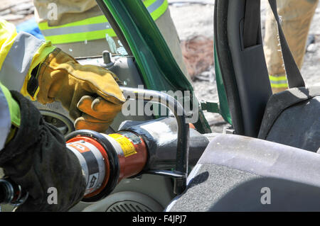 Vigili del fuoco utilizza strumenti di potenza al salvataggio dei passeggeri rimasti intrappolati da un auto Foto Stock