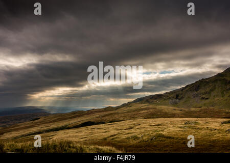 Raggi crepuscolari dal vecchio uomo di Coniston e Dow Crag nel Parco Nazionale del Distretto dei Laghi, con cicatrice Walna Road Foto Stock