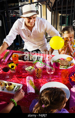 I genitori e le figlie di mangiare il pranzo sul balcone Foto Stock