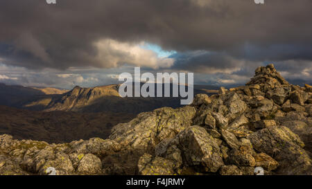 La vista dalla cima del Wetherlam, guardando verso un sun-imbevuto Langdale Pikes nella luce del mattino. Foto Stock