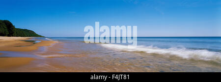 Onde che si infrangono sulla spiaggia vuota Foto Stock