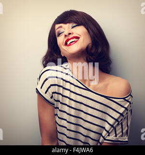 Divertimento ridere giovane donna con capelli corti e gli occhi chiusi. Ritratto vintage Foto Stock