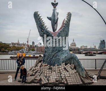 Londra, Regno Unito. 18 ottobre, 2015. Un gigante dinosauro Mosasaurus mangiare una grande squalo bianco è stata svelata al South Bank punto di osservazione per celebrare il rilascio di Blu-ray e DVD di mondo giurassico, oggi, 18 ottobre, 2015. Credito: Pete Maclaine/Alamy Live News Foto Stock