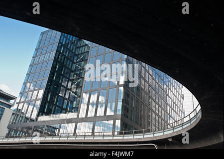Basso angolo di visione di un ufficio moderno edificio con adiacente strada sopraelevata Foto Stock