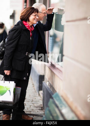 Coppia matura window shopping, sorridente Foto Stock