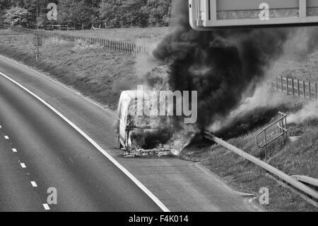 I vigili del fuoco di mettere fuori un furgone fire in autostrada Foto Stock