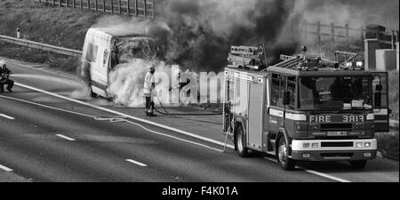 I vigili del fuoco di mettere fuori un furgone fire in autostrada Foto Stock