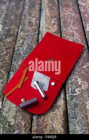 Borsetta rossa su una a doghe di sfondo di legno Foto Stock