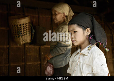 Ragazza giovane e donna old della Loi tribù dentro la loro casa in Wun Nyat, un villaggio vicino alla frontiera cinese, stato Shan, Myanmar Foto Stock