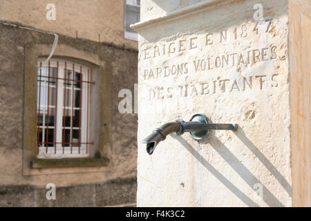 Commemorativo rubinetto di acqua in un pilastro di pietra in Greoux-Les Bains Francia con la scritta Erigee en 1847 perdona Voluntaires d Foto Stock