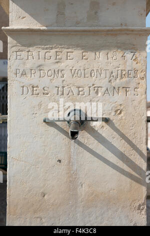 Commemorativo rubinetto di acqua in un pilastro di pietra in Greoux-Les Bains Francia con la scritta Erigee en 1847 perdona Voluntaires d Foto Stock