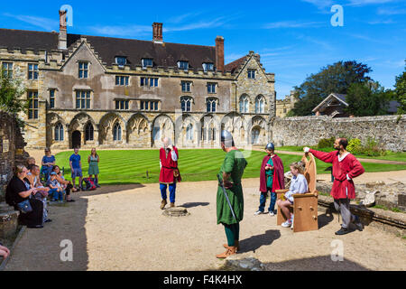 Visitatori participatiing nella rievocazione storica di fronte all abate della grande hall (ora una scuola) all Abbazia di Battle, e Sussex, Regno Unito Foto Stock