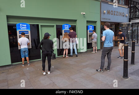 Persone ritirare contanti da ATM Bancomat in Londra England Regno Unito Regno Unito Foto Stock