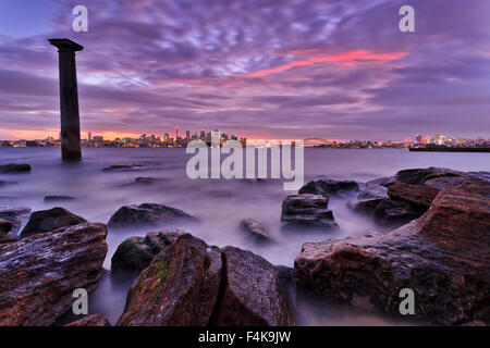 La città di Sydney CBD landmarks veduta distante da Bradley della testa del parco nazionale al tramonto quando la città è illuminato e respiro umido Foto Stock