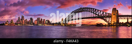 Burning bright tramonto su Sydney CBD cityline panoramically raffigurato in tutta Harbour compresi i grattacieli e Harbour Bridge Foto Stock