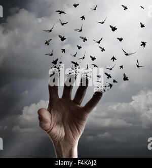 La vita il concetto di trasformazione come una mano protesa tranforming in uccelli in volo seguendo la luce solare come un simbolo di libertà di speranza Foto Stock