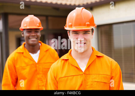 Felice giovani builder e collaboratore nella parte anteriore della nuova casa Foto Stock
