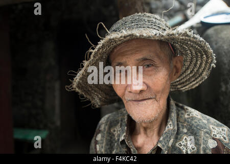 Il contadino, USTRA Castro, 81, di prendere un periodo di riposo al di fuori della sua casa in Sabtang isola. Foto Stock