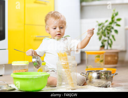 Little Boy giocando con stoviglie e prodotti alimentari in cucina Foto Stock