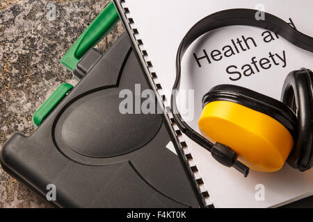 La casella degli strumenti di colore nero con gli auricolari e la salute e sicurezza documento Foto Stock