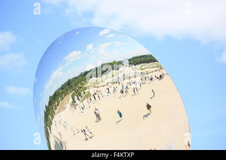 Riflessi di turisti non identificato in lo specchio sferico Foto Stock