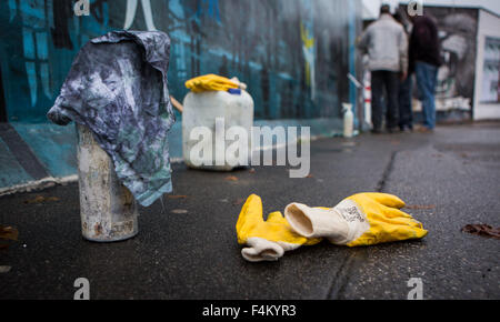 Prodotti di pulizia e i guanti a terra vicino alla East Side Gallery di Berlino (Germania), 20 ottobre 2015. Durante la pulizia al più lungo la restante sezione del muro, graffiti viene rimosso e le opere d'arte conservati. Fori di calcestruzzo sono anche riparato. Foto: Sophia Kembowski/dpa Foto Stock