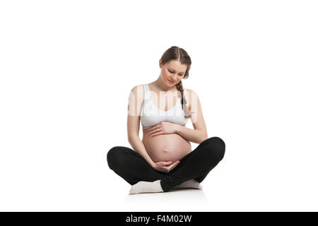 Sport donna incinta facendo esercizio di stretching Foto Stock